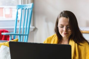 young woman looks at the computer screen.